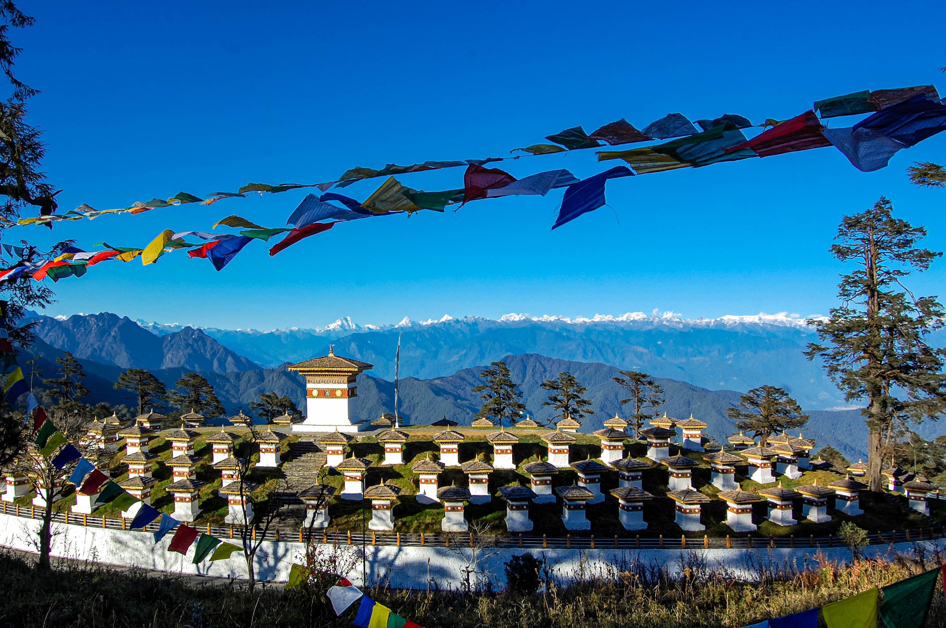 The 108 chortens at Dochula pass under prayer flags, with the eastern Himalaya behind