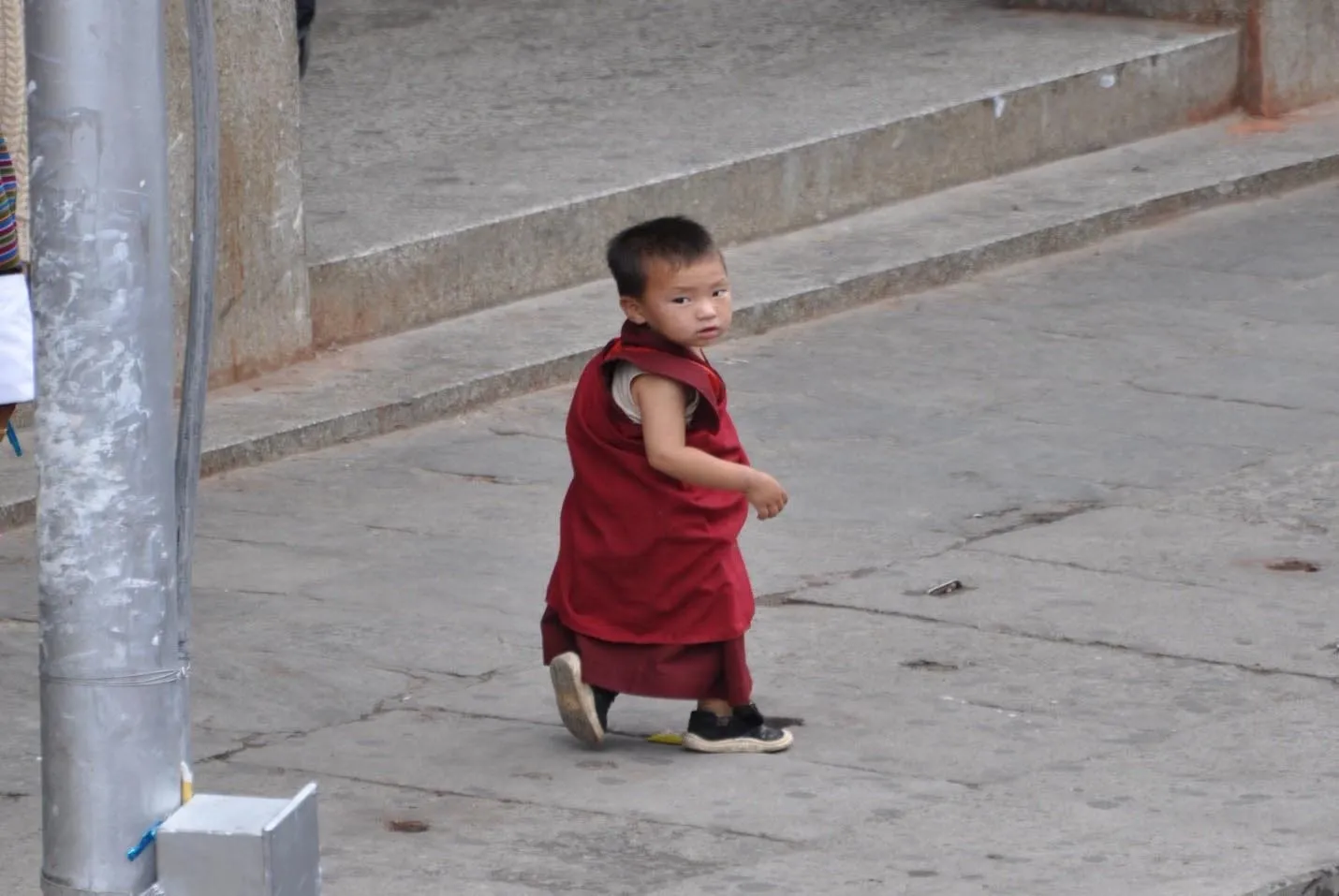 A young monk turns to the camera on the streets of Thimphu.